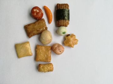 Preparato al forno croccante del cracker del riso con i piselli delle arachidi rivestite